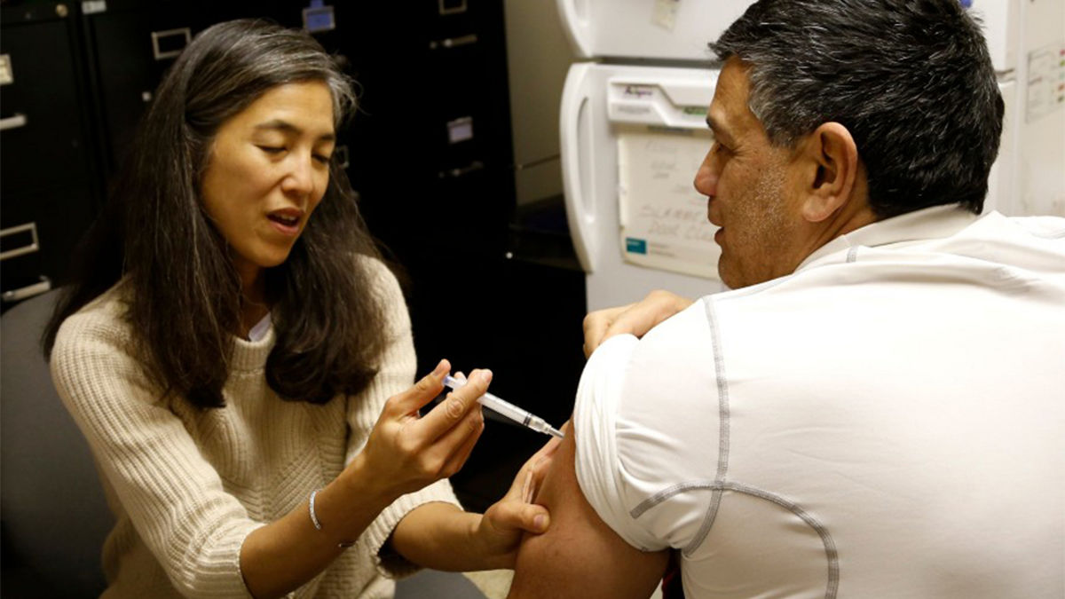 Dr. Morita giving a flu shot at a clinic during her tenure with the Chicago Department of Public Health.