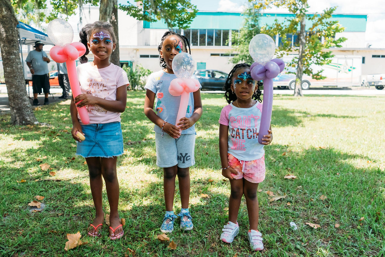 Victoria, 7 years old, Gianna, 5 years old & Gabrielle, 3 years old, happy with their balloons and face paint on Founders Day.