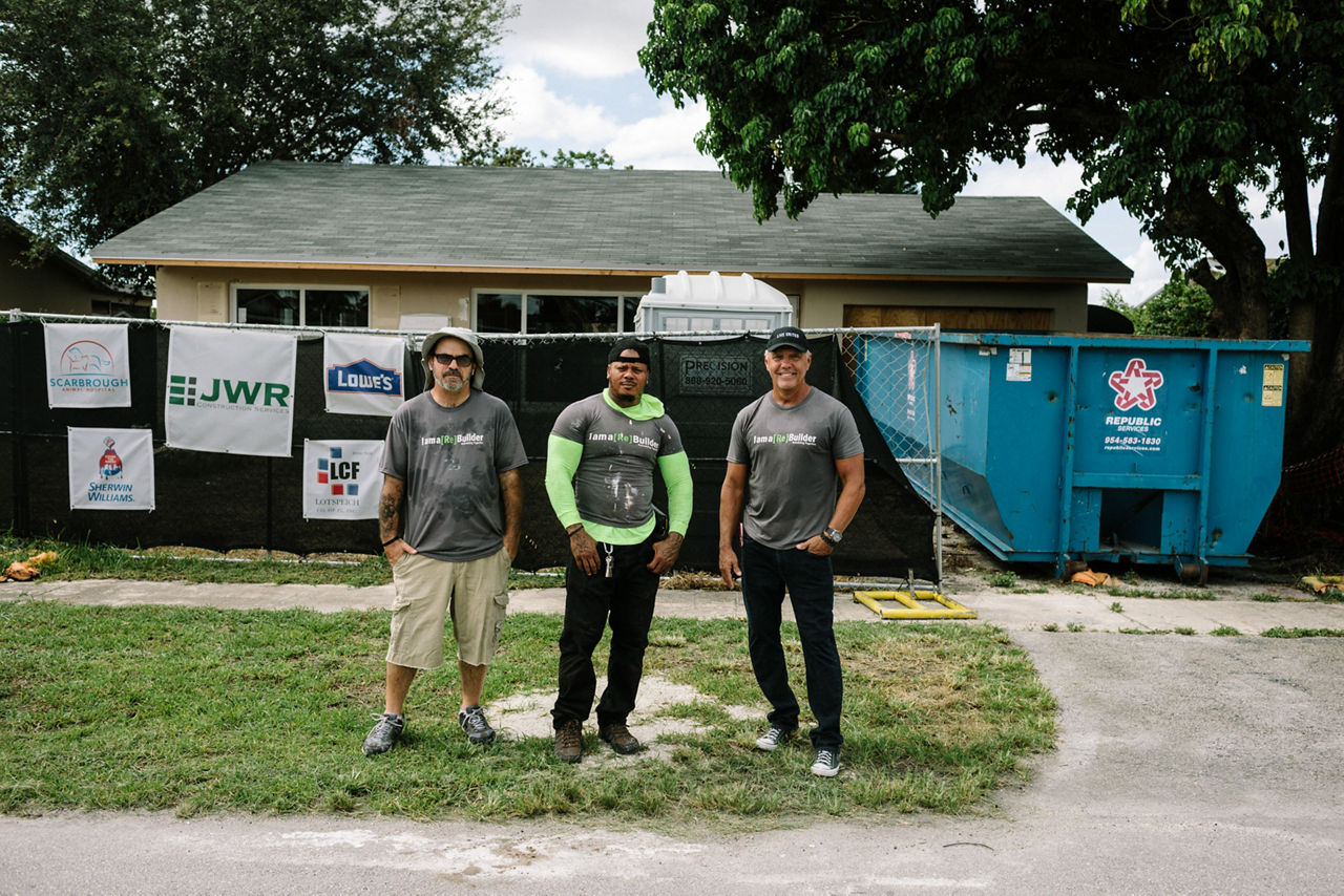 Broward County, FL - August 21, 2019 - (L to R) Patrick Shea, Terrance Roberts, and Jason Mann stand in front of a house that the nonprofit Rebuilding Together is restoring at no cost to the occupant.