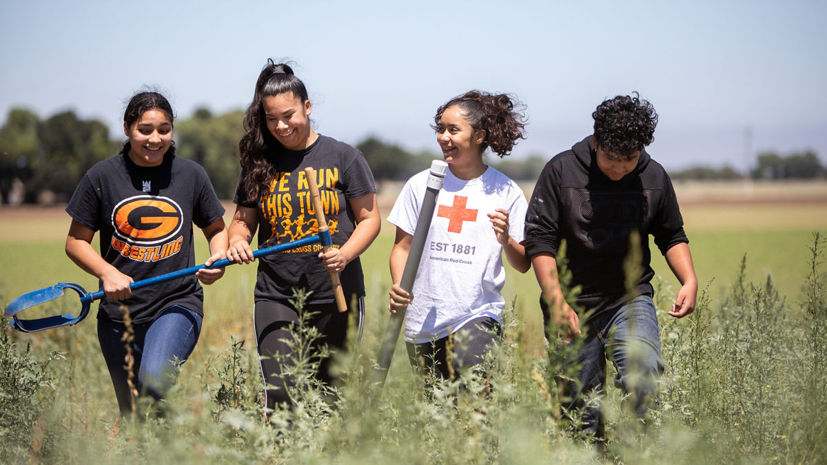 RWJF Culture of Health Prize 2019 - Gonzales, CA. Veronica Rodriguez (left), Maria Lopez (white shirt), Leslie Hernandez (2nd to left in "we run this town " shirt) and Andres Hernandez (the only male here). Wings of Knowledge program, which started in 2015. The program has equipped Gonzales High and Middle school students with a focus on the curriculum application of STEAM: Science, Technology, Engineering, Arts and Mathematics. Wings of Knowledge (WOK) is participatory action-research initiative guided by the non-profit Olinga Learning.  Olinga Learning is dedicated to empowering youth to improve their rural communities.
