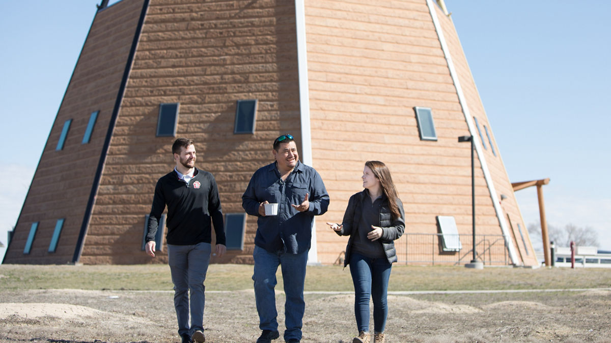 Todd County, South Dakota, 2019. Rosebud Reservation.The Lakota Studies Tipi Building located at Sinte Gleska University.Kevin “Hoch” Decora (center) is Lakota and an enrolled Tribal member of the Winnebago of Nebraska Tribe and currently works as a Professor at Sinte Gleska University (SGU).Stephanie Prinsen (right) is a Physical Therapy student and part of the LEND Program. She is a student at SDU and is visiting SGU to learn about their offering. Tanner Munk (left) is a Physical Therapy student at the University of South Dakota and is also a part of the LEND Program.