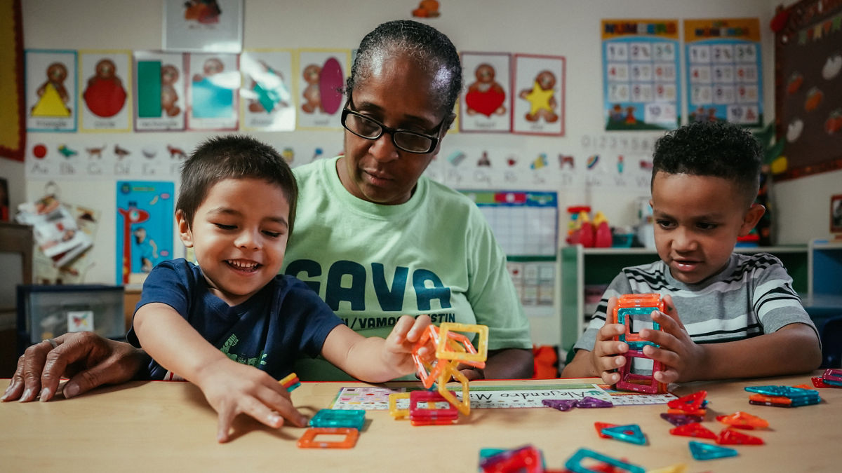 Ms. Loretta Johnson playing with magnetic tiles with King Johnson and Aiden Briggs at her Family Childcare facility.
