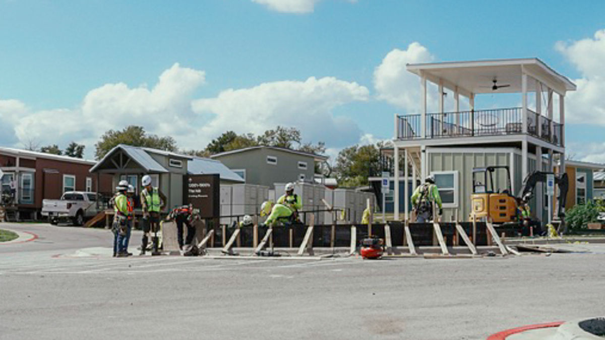 A group of men in hard hats working on a construction project under a beautiful blue sky.