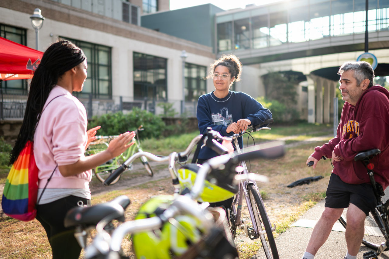 (L-R) Kyra Miles, Carmen De Souza Bronshteyn and Vladimir Bronshteyn talk before beginning the Slow Roll, a community bike ride led by Anthony Taylor and the Cultural Wellness Center on September 15, 2023. Slow Roll is an event gathering that looks at the art, history and culture of a community.