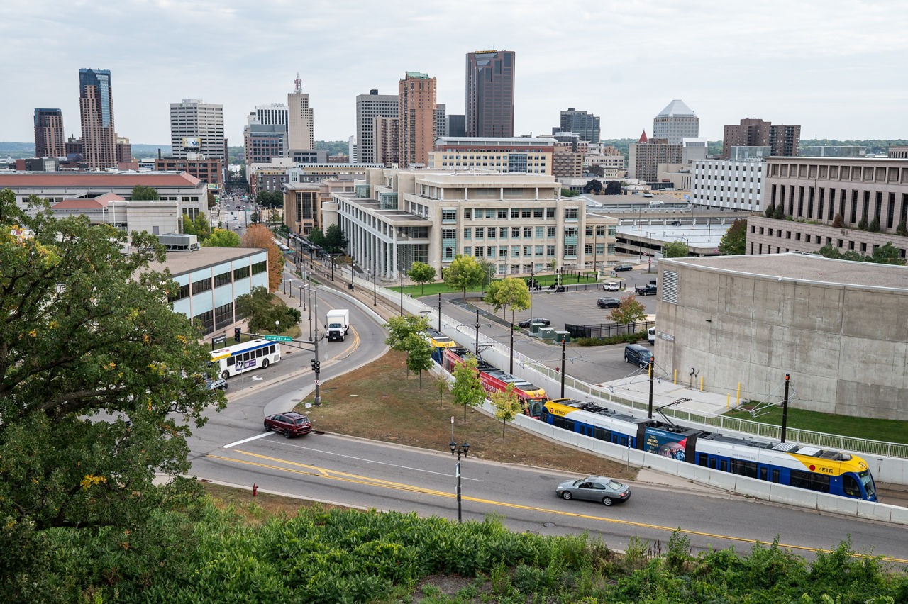 A view of the city of St. Paul with buildings, roads with cars, and some greenery.  