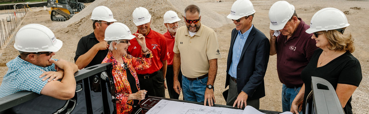 Iola, KS - August 1, 2017 - Members of THRIVE Allen County, construction staff, and and community officials discuss plans for a new grocery store in downtown Iola.
