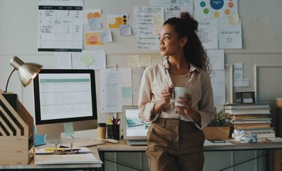 Person at their desk in office with coffee