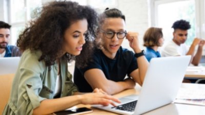 Two students collaborating on laptop