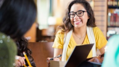 Two female friends collaborating at desk