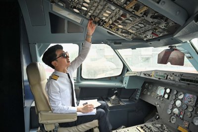 Pilot completing preflight checks in plane cockpit.
