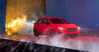 2024 Subaru Impreza driving through water, simulating a rainstorm, during its reveal at the Los Angeles Auto Show