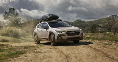 Crosstrek Hybrid with accessory equipment driving down a winding road.