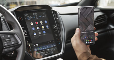 A man connects a smartphone to a Subaru Impreza touchscreen using Apple CarPlay.