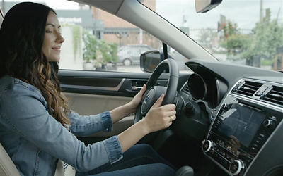 A woman in a Subaru vehicle using TomTom navigation