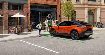 Subaru electric vehicle SUV parked outside retail storefront 