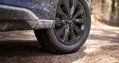 A close-up of a black alloy wheel on the 2025 Subaru Outback showing its ground clearance.