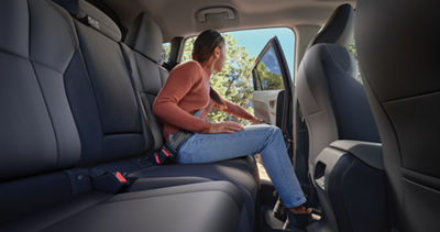 A woman sitting in the rear passenger seats of a 2026 Subaru Crosstrek.