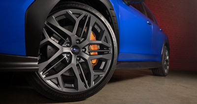 Un primer plano de una rueda y frenos Brembo en un Subaru WRX tS.