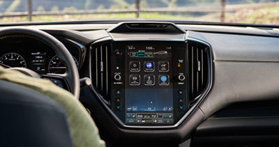 Dos niños con auriculares ven videos en tabletas en la tercera fila de asientos del Subaru Ascent 2026. 