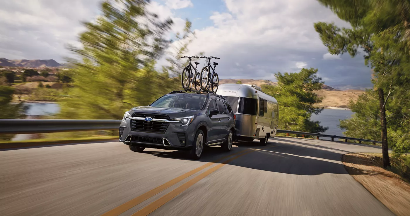 A Subaru Ascent towing an Airstream trailer with bikes on the roof