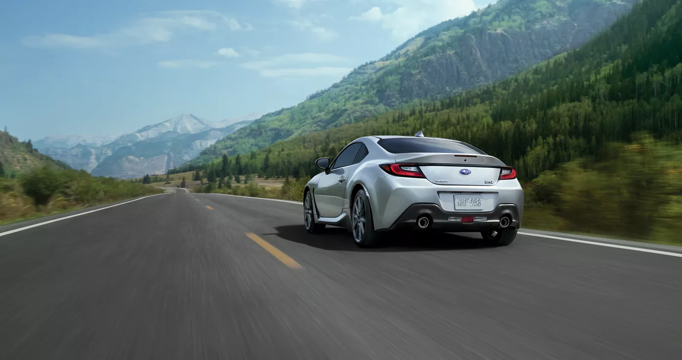 A silver Subaru BRZ on a mountain road, seen from behind