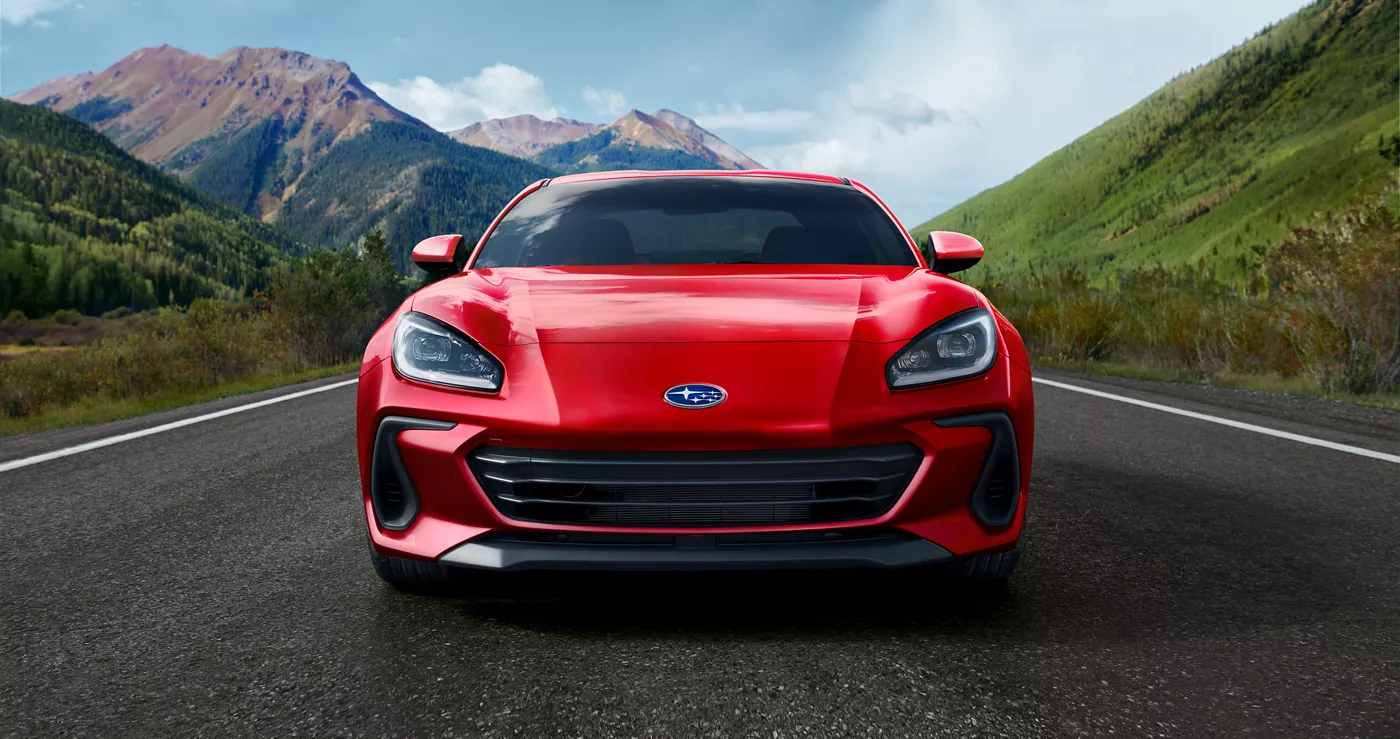 The front of a red Subaru BRZ on a mountain road