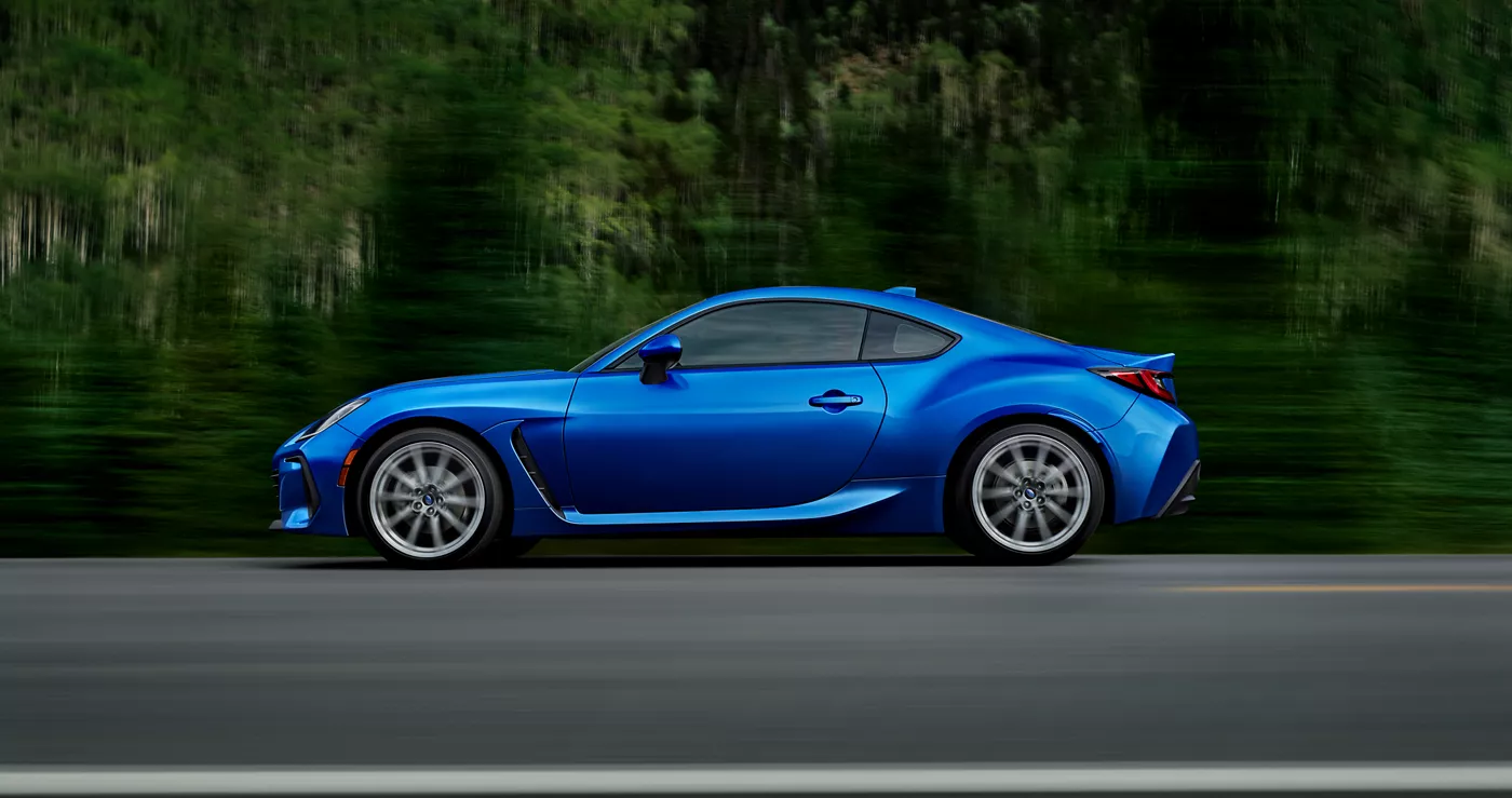 A blue Subaru BRZ in profile at speed