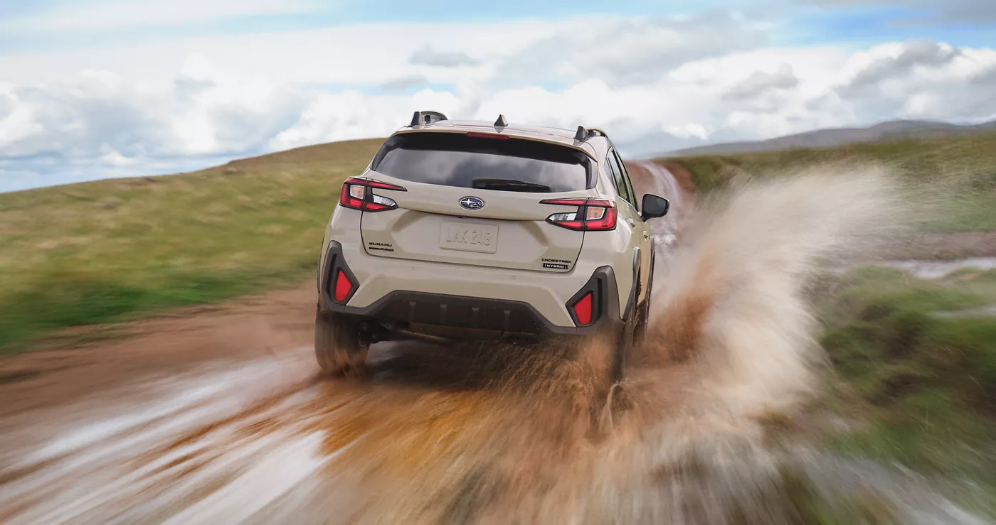 A Subaru Crosstrek throwing up mud on a dirt track
