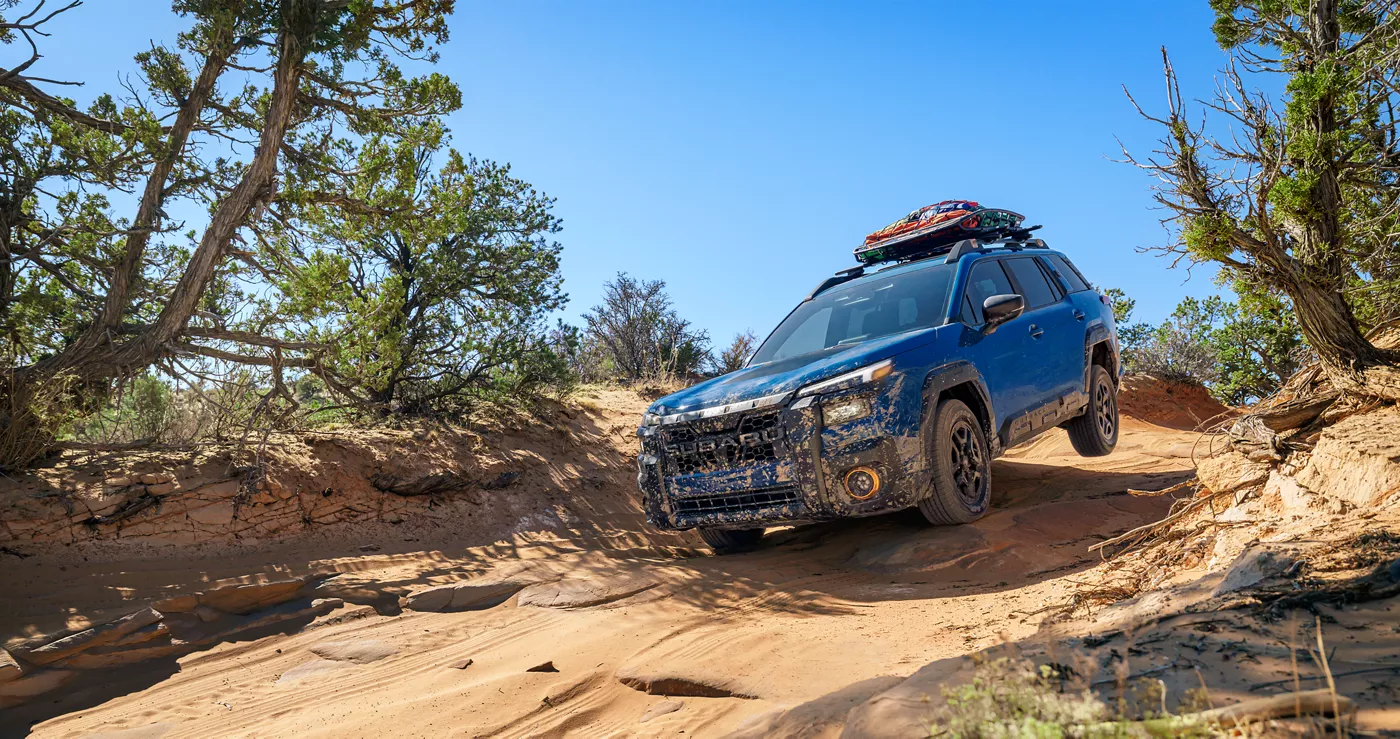 A blue Subaru Outback Wilderness on red rock