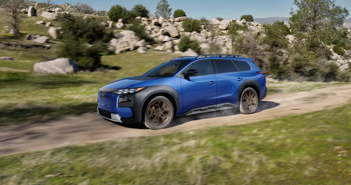 A blue Subaru Trailseeker on a boulder-strewn dirt road