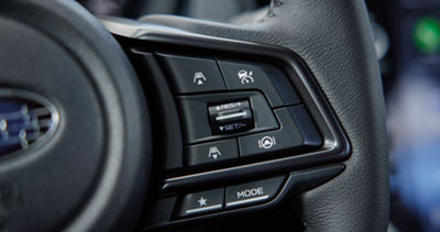 A close-up of the Drive Mode Select button on the steering wheel.