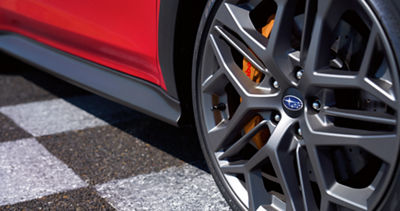 A close-up on a wheel and gold-finished Brembo brakes on a Subaru WRX tS.