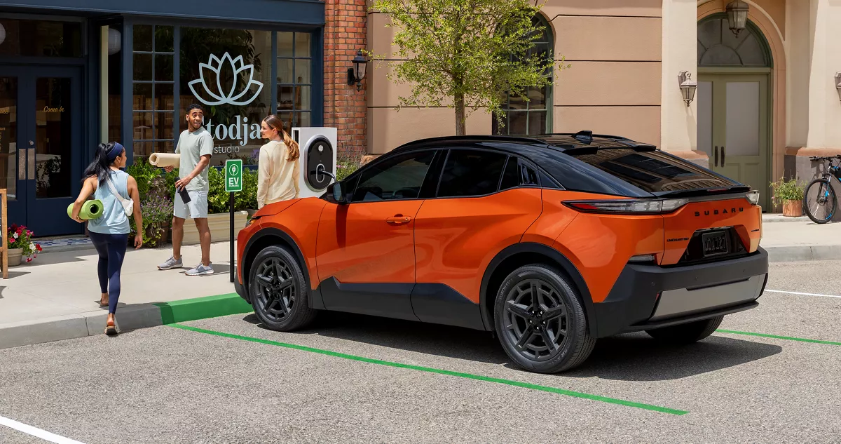 Orange Subaru Uncharted plugged in at a curbside EV charger
