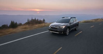 MY20 Outback driving on mountain highway with sun setting in background