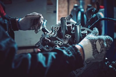 Closeup repair of an opposing engine by an auto mechanic.