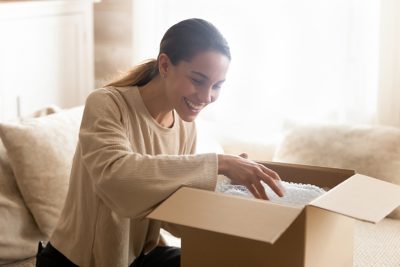 woman smiling and opening a package