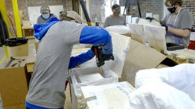 employee using SEALED AIR brand PUR foam for ChillPak covid-19 vaccine shipper