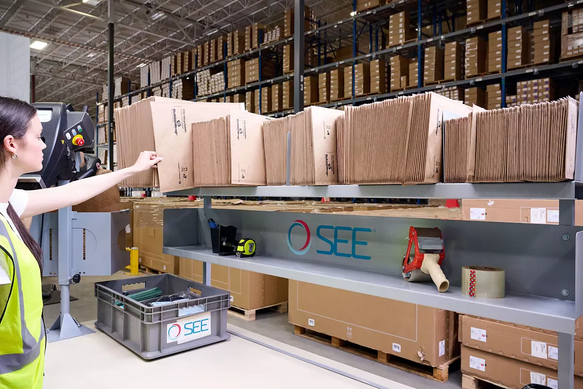 warehouse worker selecting paper bubble mailer to package items