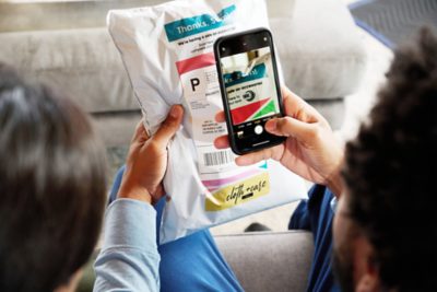 Mann scannt Verpackung mit Smartphone