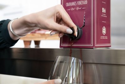 woman pouring boxed wine into a glass