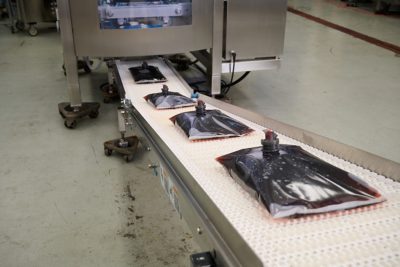 liquid food products in plastic pouch on a conveyor belt