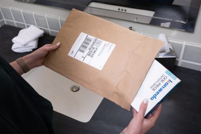 woman opening an order packed in a Jiffy Padded mailer