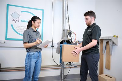 woman holding a clipboard and man holding cardboard box