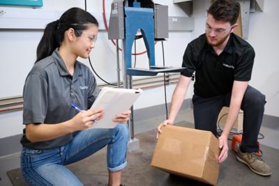 two engineers performing integrity testing on a package