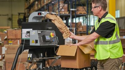 warehouse worker loading protective packaging into a box