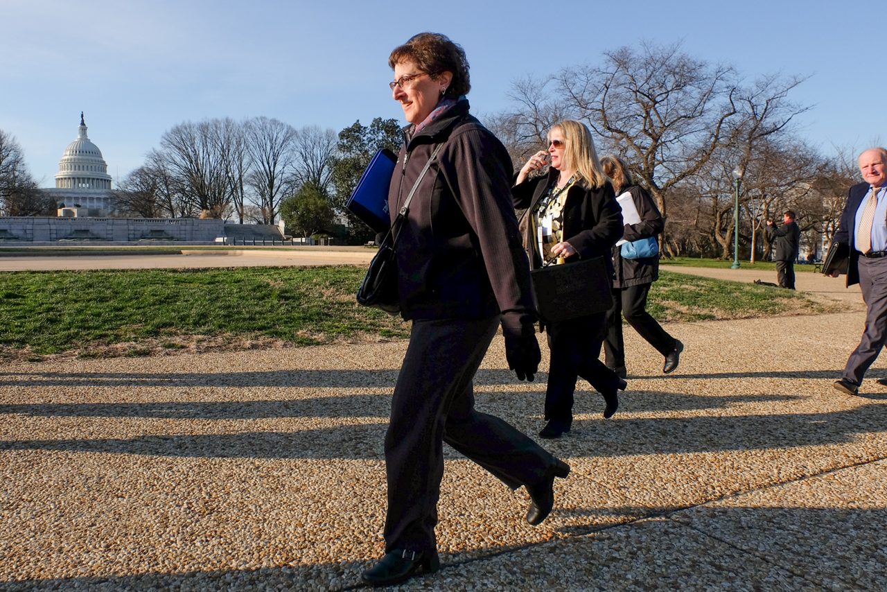 woman walking with folder in front of us capitol