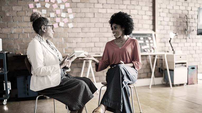 Two women talking in an office.