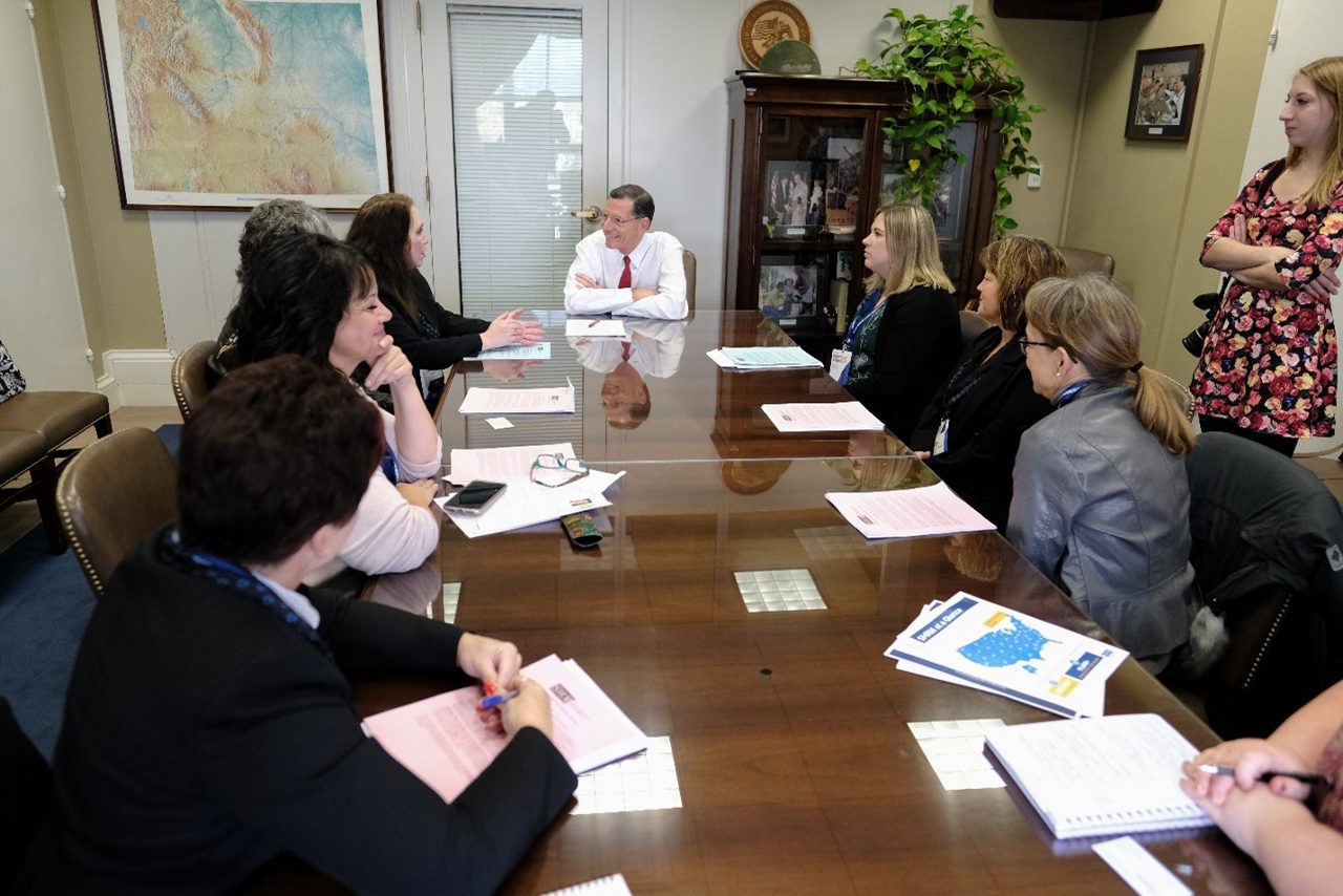 people meeting at a conference table with a senator