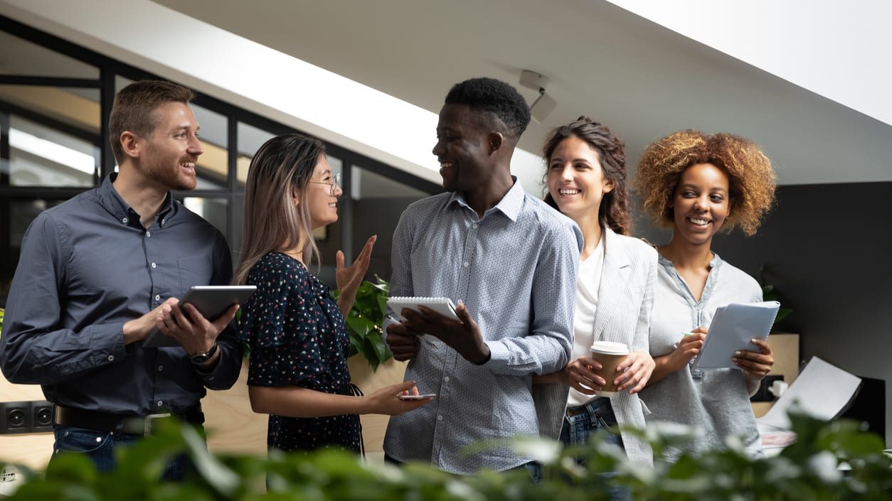 diverse group of coworkers holding tablet computers smiling