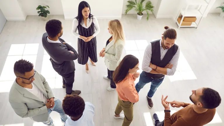 group of people standing in a room talking